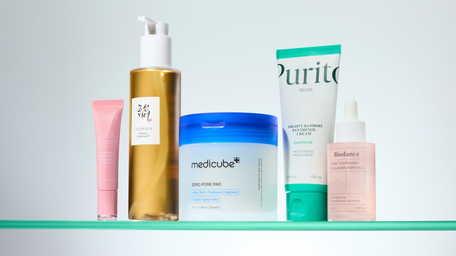 A lineup of five different Korean skincare products, all on a shelf and with colourful packaging