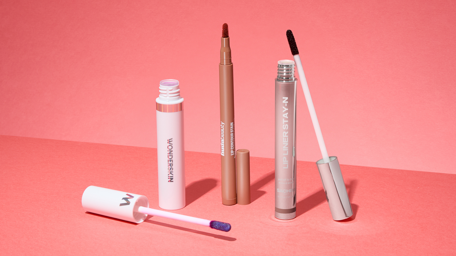 Three lip stain products laid out next to one another, each one with the lid removed.