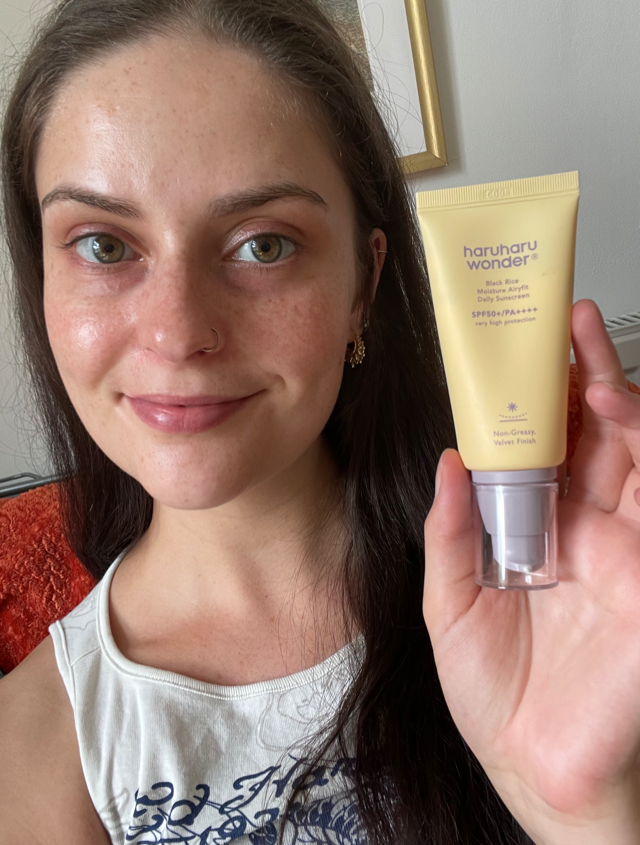 Someone holding the haruharu wonder SPF in yellow and purple packaging