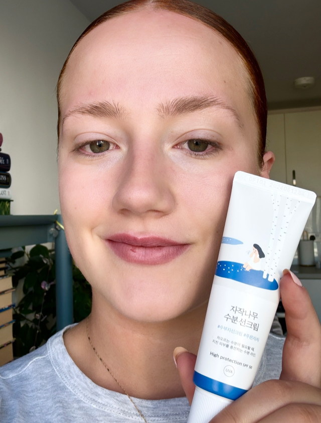 Someone holding the Round Lab sun cream in white and blue tube