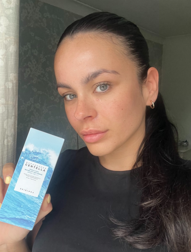 Someone holding the SKIN1004 SPF in a white and blue box