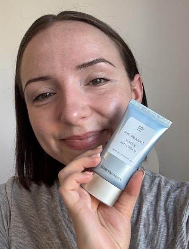Someone holding the Thank You Farmer SPF in blue packaging