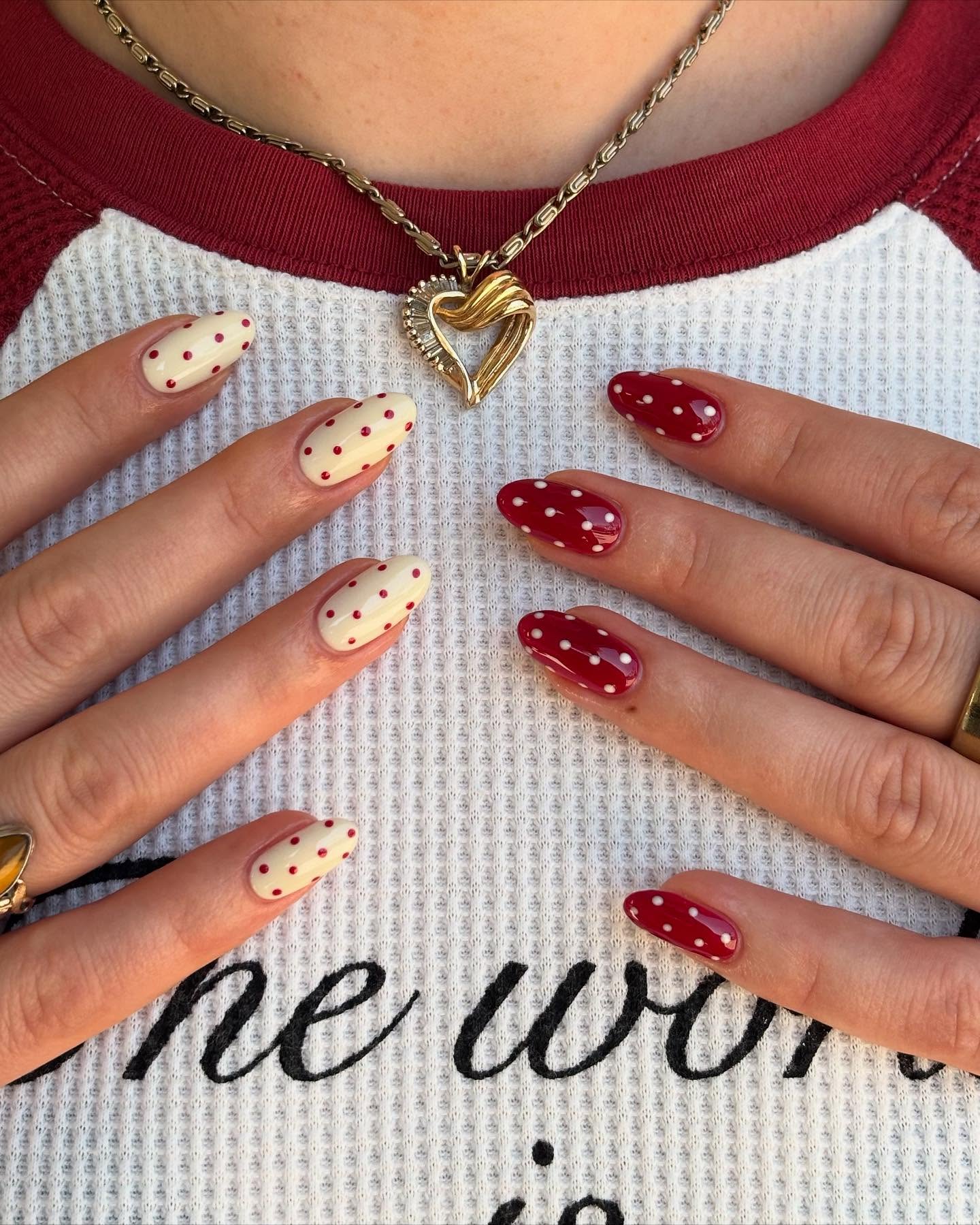 Two hands with opposite polka dot nails in red and yellow shades