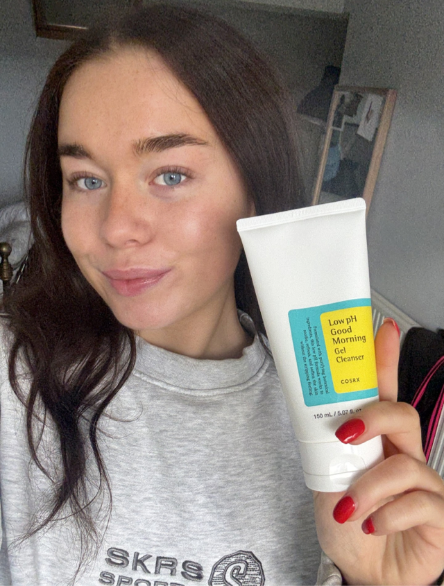 Someone holding the COSRX cleansing gel with glowing, clear skin