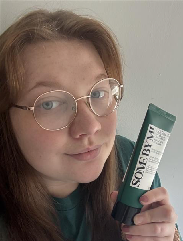 Someone holding the SOME BY MI cleansing gel in green and white packaging