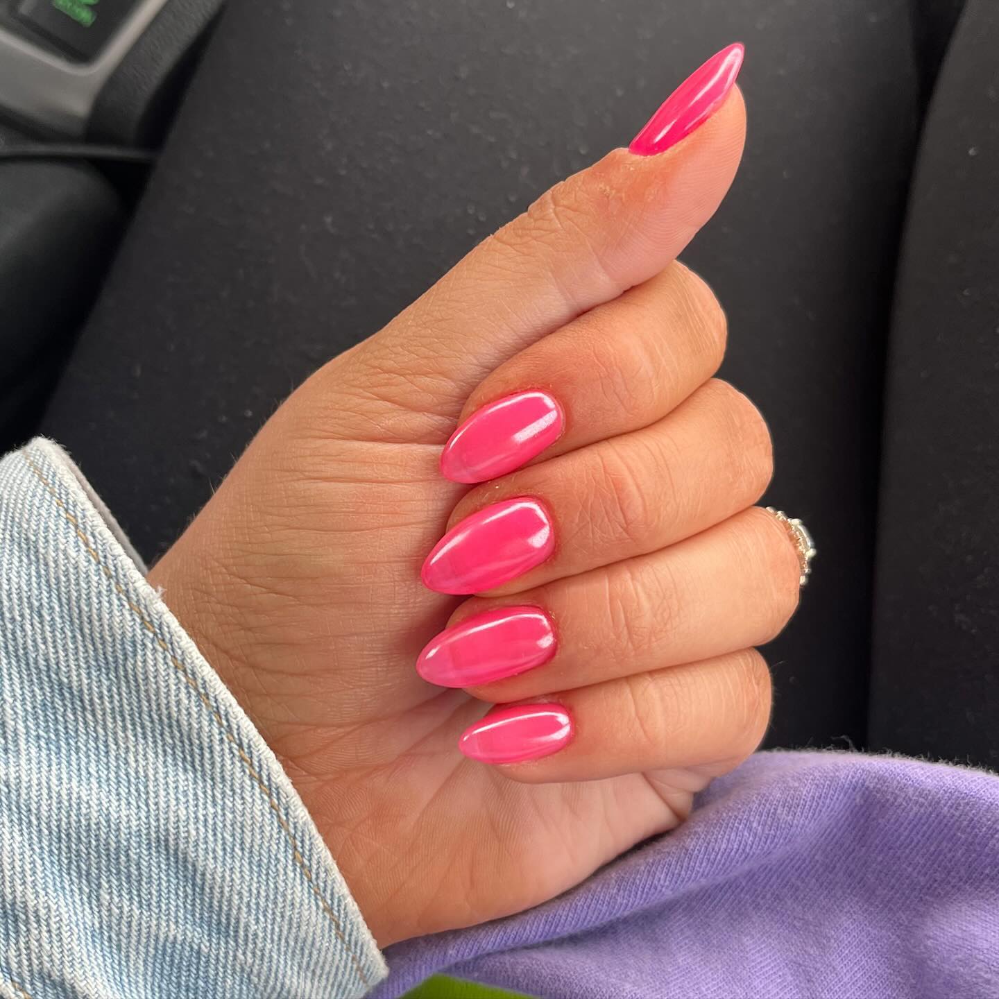 A close up of a hand with almond shaped nails with pink jelly nails design