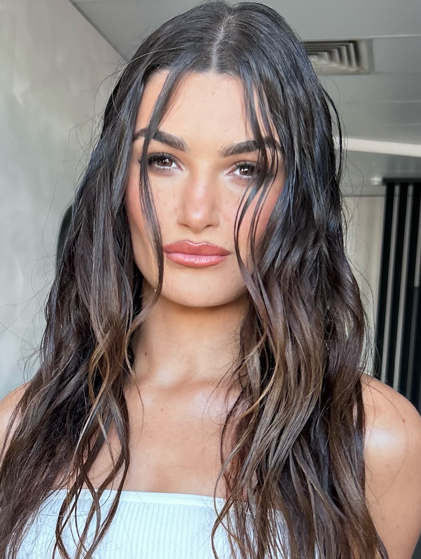 A woman with mid-length wet look curls